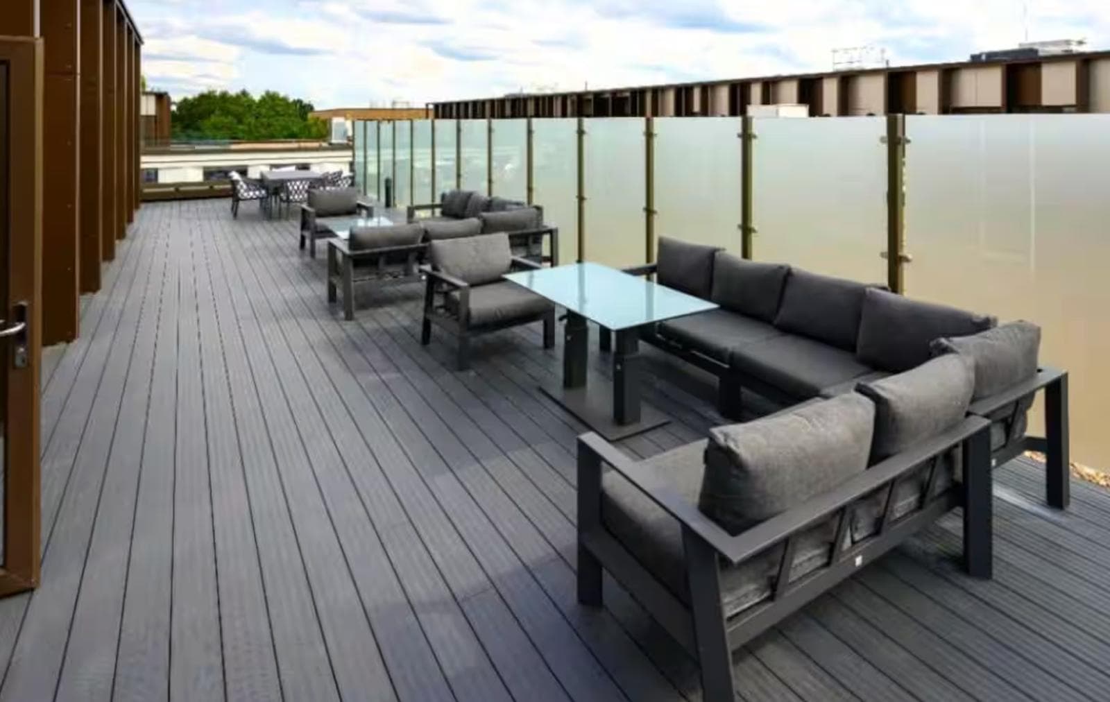 Spacious rooftop terrace with modern lounge seating and stylish privacy screens